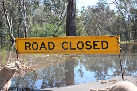 Road Closed sign across flooded road